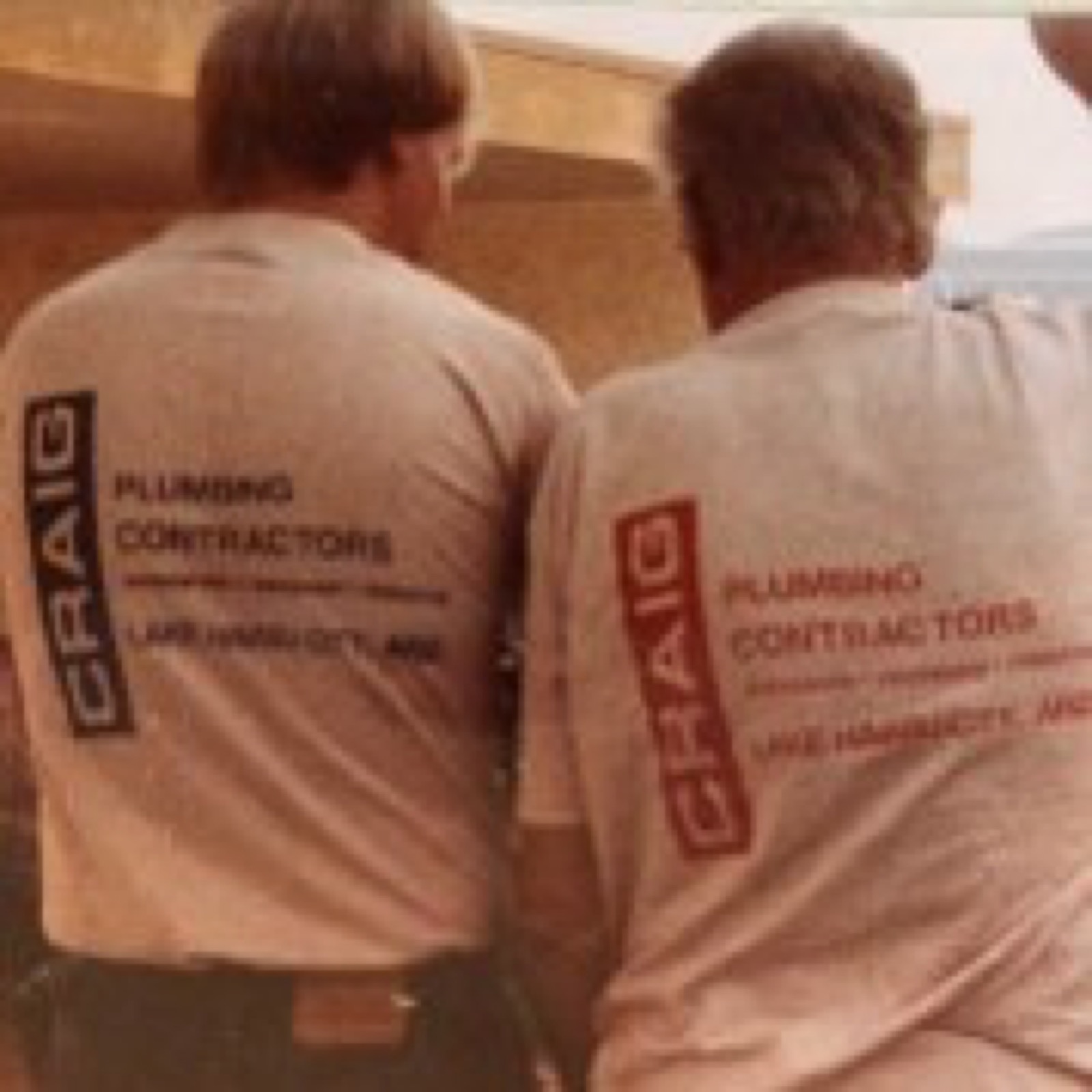 Two crew members in original Craig Plumbing Contractors shirts